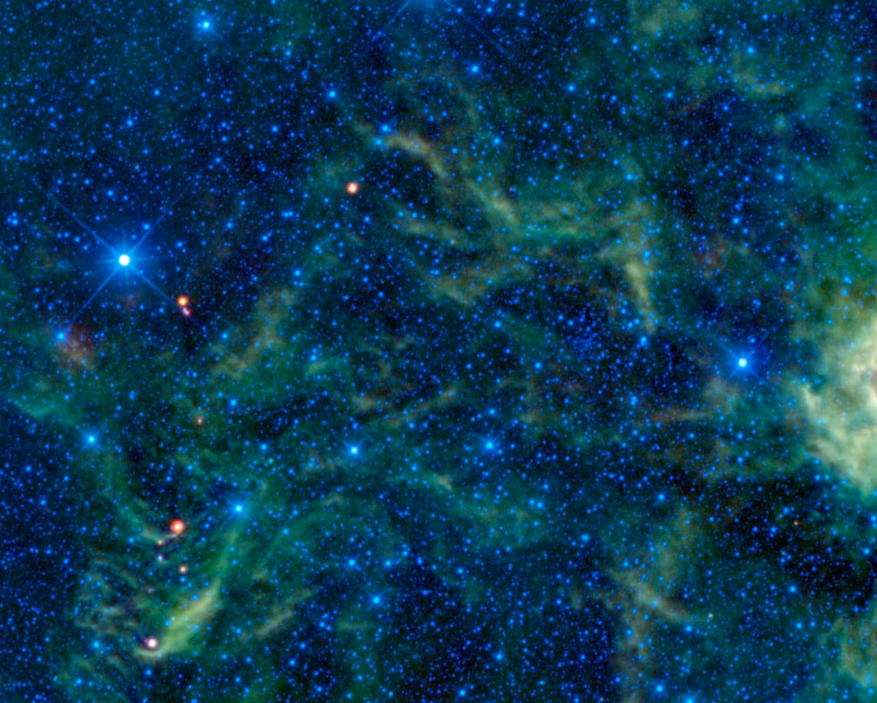 The Pleiades open star cluster, with bright blue stars surrounded by faint blue reflection nebulosity.